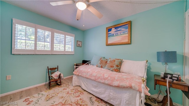 bedroom with a ceiling fan, baseboards, and wood finished floors