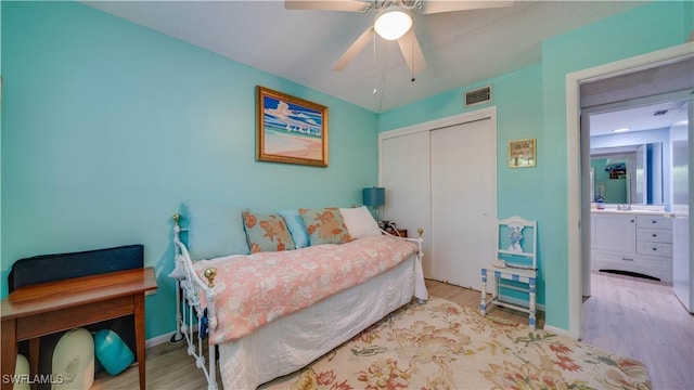 bedroom featuring ceiling fan, visible vents, a closet, and wood finished floors