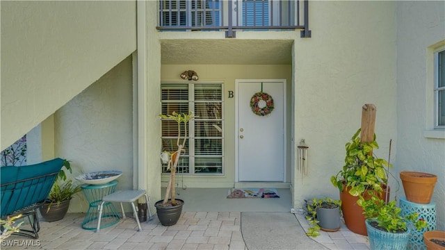 doorway to property with a patio area and stucco siding