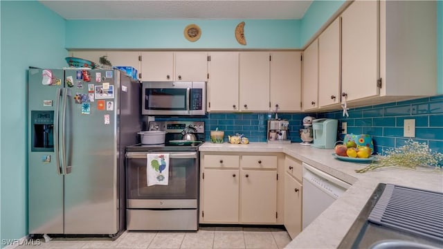 kitchen with stainless steel appliances, backsplash, and light countertops