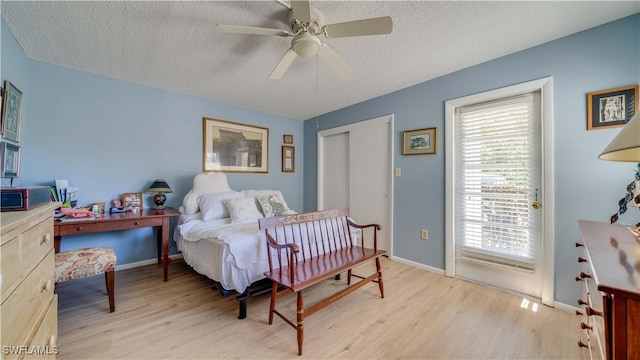 bedroom with light wood-style flooring, a textured ceiling, and baseboards