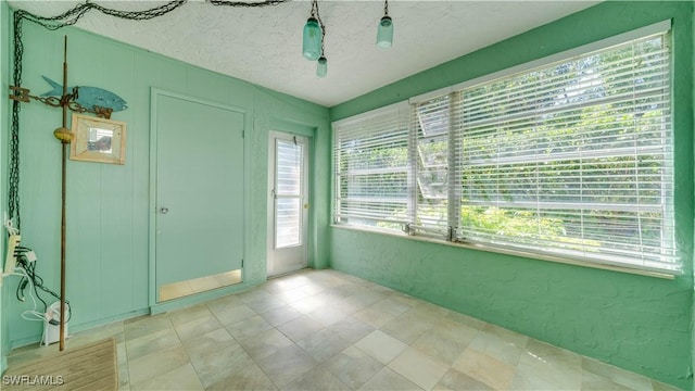 empty room with a textured ceiling and a textured wall