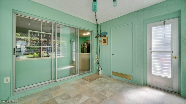 doorway to outside featuring a wealth of natural light and a textured ceiling