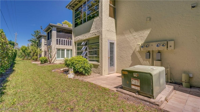 exterior space featuring a patio, a yard, and stucco siding