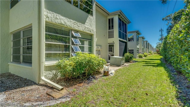 view of property exterior with stucco siding and a yard