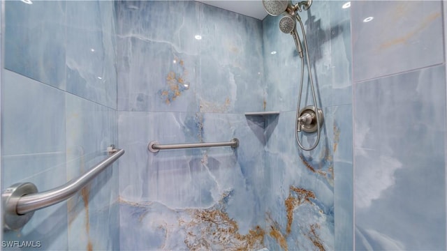 interior details featuring a marble finish shower