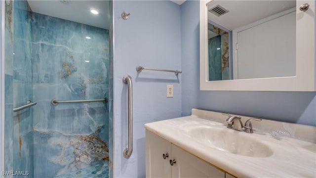 bathroom with a marble finish shower, visible vents, and vanity