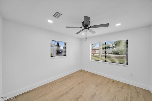 empty room with light wood-style floors, baseboards, visible vents, and recessed lighting