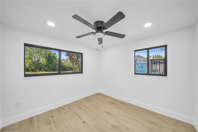 spare room with a healthy amount of sunlight, light wood-style floors, baseboards, and recessed lighting