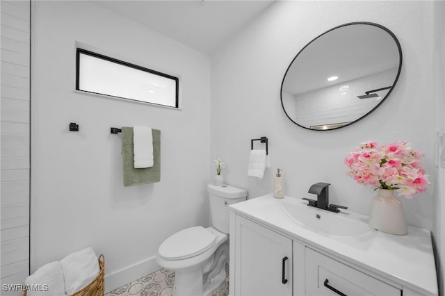 bathroom with baseboards, vanity, and toilet