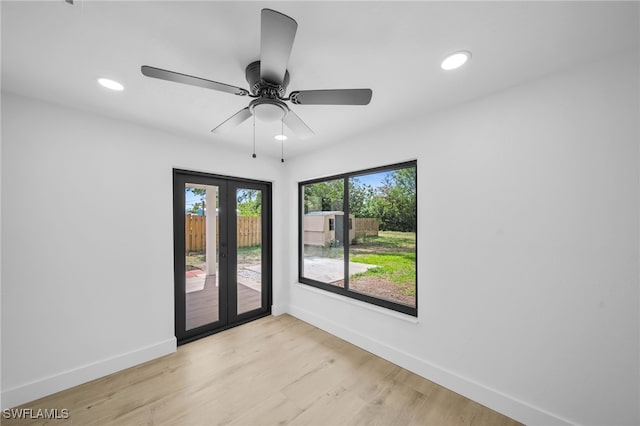 spare room with baseboards, a ceiling fan, french doors, light wood-style floors, and recessed lighting