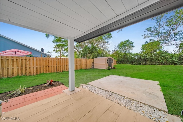 view of patio with an outbuilding, fence, and a storage shed