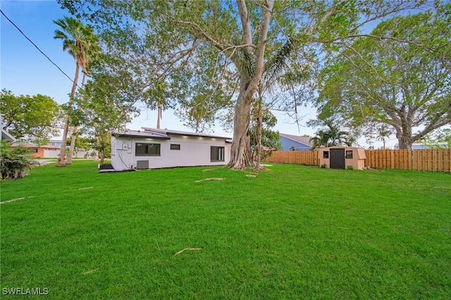 view of yard featuring a shed, fence, and an outbuilding