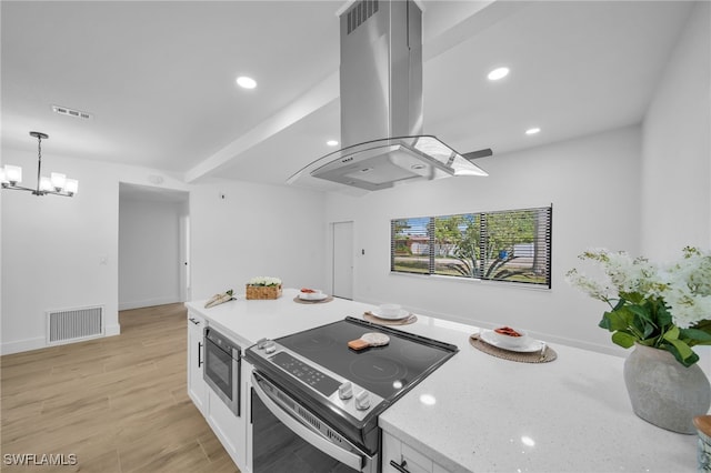 kitchen featuring island exhaust hood, light wood-style flooring, white cabinets, built in microwave, and stainless steel electric range