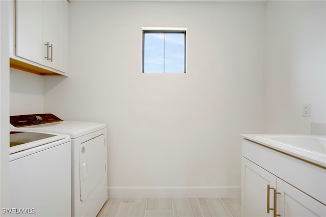 laundry room with separate washer and dryer, a sink, cabinet space, and baseboards