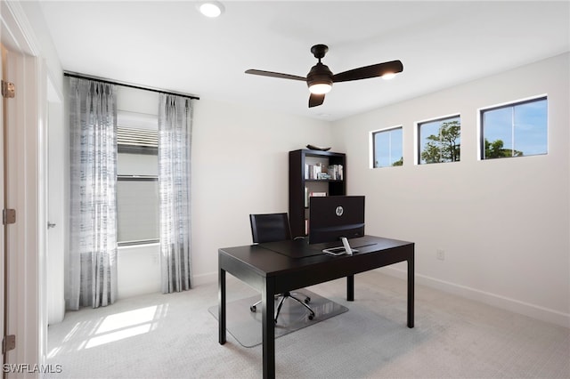 carpeted office space with baseboards and a ceiling fan