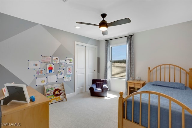 bedroom featuring a closet, a ceiling fan, and light colored carpet