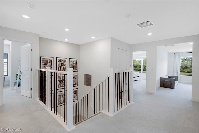 hall featuring visible vents, carpet floors, an upstairs landing, and recessed lighting