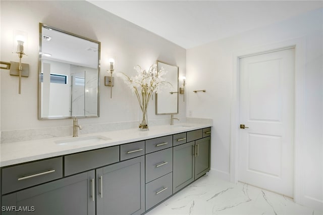 bathroom with marble finish floor, a sink, baseboards, and double vanity