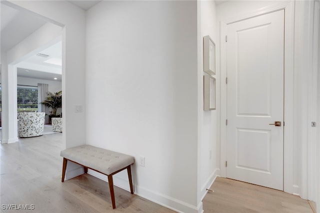 hall featuring light wood-type flooring and baseboards