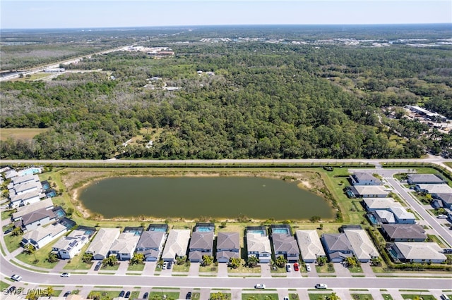 drone / aerial view with a water view, a wooded view, and a residential view