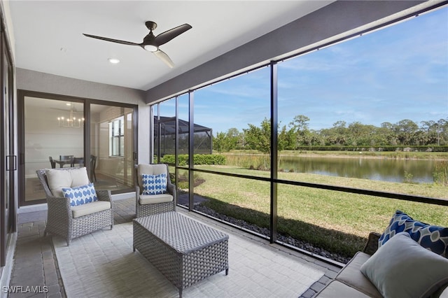 sunroom with a water view and ceiling fan with notable chandelier