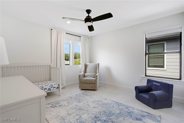 living area with ceiling fan and baseboards