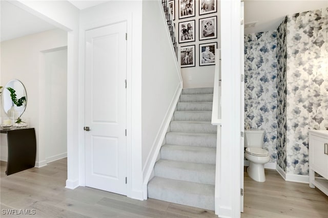 staircase featuring baseboards and wood finished floors