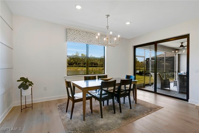 dining area featuring a chandelier, plenty of natural light, wood finished floors, and baseboards