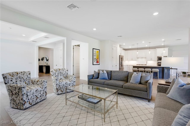 living room with recessed lighting, baseboards, visible vents, and light wood finished floors