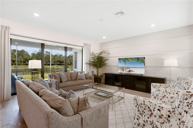 living area with light wood-type flooring, visible vents, and recessed lighting