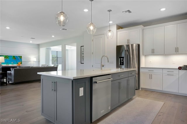 kitchen featuring gray cabinets, light countertops, visible vents, light wood-style flooring, and appliances with stainless steel finishes