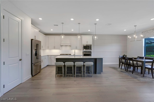 kitchen featuring stainless steel appliances, light wood finished floors, visible vents, and white cabinetry