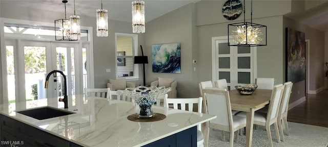 dining room with a chandelier, vaulted ceiling, and french doors