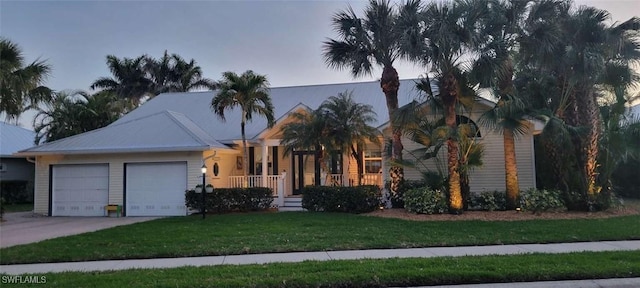 view of front of house featuring a front lawn, concrete driveway, and an attached garage