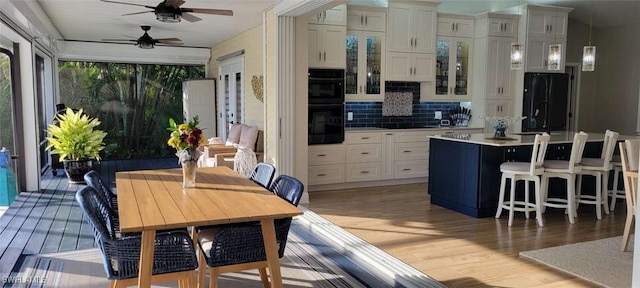 kitchen featuring black appliances, light wood-style flooring, white cabinets, and light countertops