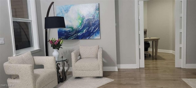 sitting room with baseboards and wood finished floors