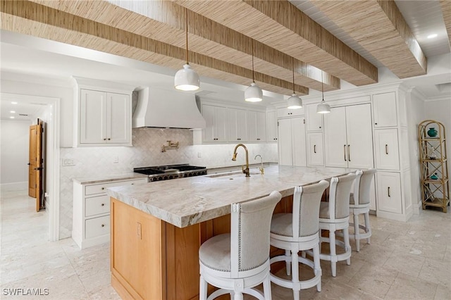 kitchen with beam ceiling, custom range hood, decorative backsplash, stove, and a sink