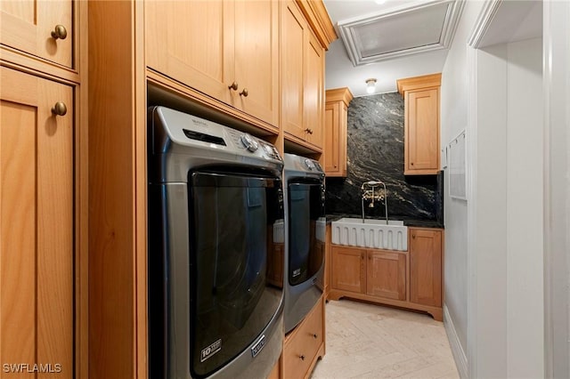 clothes washing area with attic access, a sink, and separate washer and dryer
