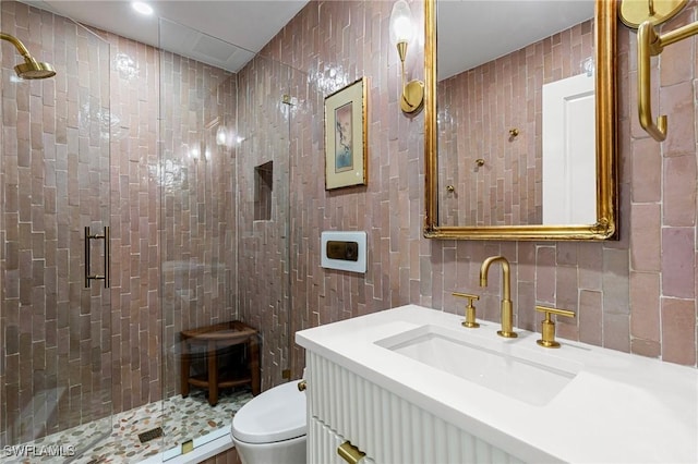 full bath featuring a stall shower, tile walls, toilet, and vanity