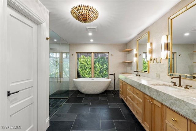 full bath with double vanity, a stall shower, and a sink