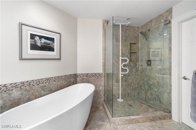 bathroom featuring a soaking tub and a shower stall