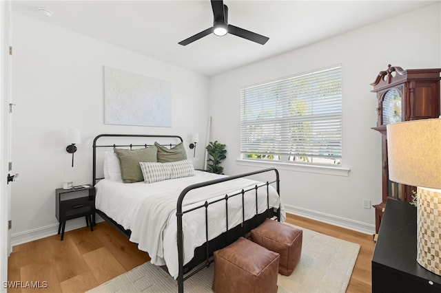 bedroom with baseboards, ceiling fan, and light wood finished floors