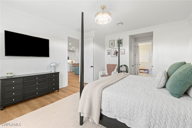 bedroom featuring crown molding, light wood-style flooring, and visible vents