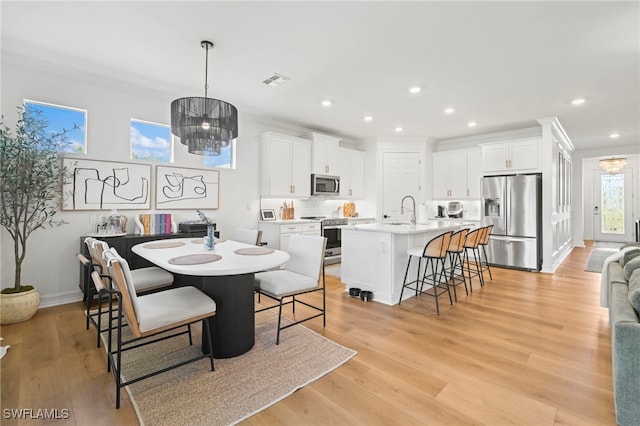 dining space with visible vents, recessed lighting, light wood-type flooring, and an inviting chandelier