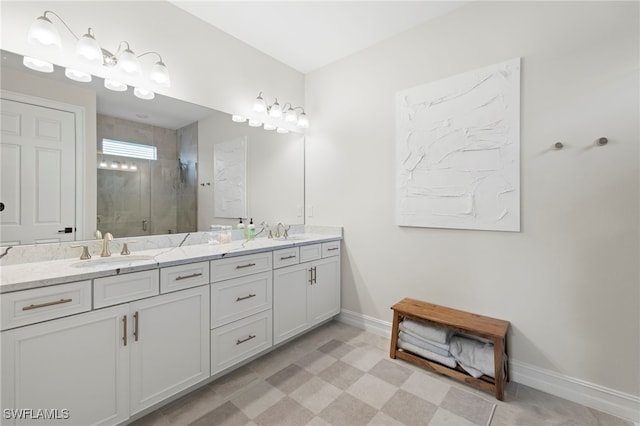 full bathroom with a sink, baseboards, double vanity, and a shower stall