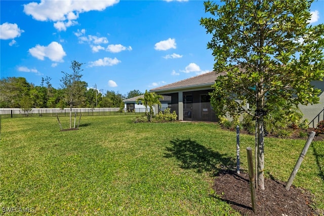 view of yard featuring a fenced backyard and a sunroom