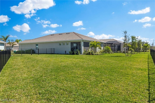 back of house with a yard, a fenced backyard, and stucco siding