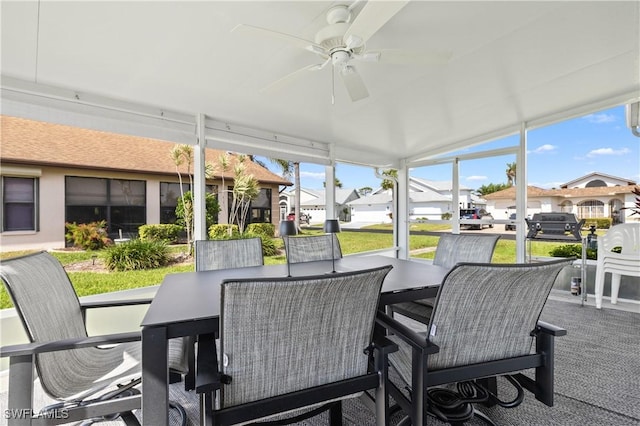 sunroom / solarium with a residential view, a healthy amount of sunlight, and ceiling fan