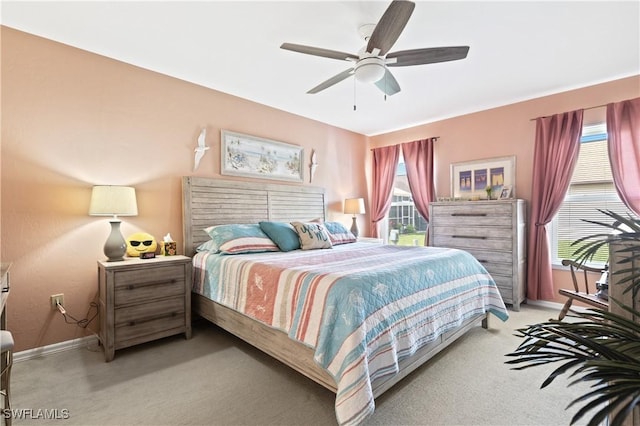 bedroom with light carpet, multiple windows, and baseboards